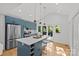 Modern kitchen boasts a large island, blue cabinets, quartz countertops, and stainless steel appliances at 1330 Dean St, Charlotte, NC 28216