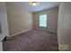 An unfurnished bedroom with carpeting, neutral walls, and a window letting in light at 13409 Glasgow Green Ln, Charlotte, NC 28213