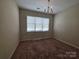 Bright bedroom with large window offering natural light and a cozy chandelier at 13409 Glasgow Green Ln, Charlotte, NC 28213
