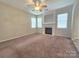 Cozy living room featuring a fireplace with decorative mantle and large windows for natural light at 13409 Glasgow Green Ln, Charlotte, NC 28213