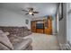 Living room features a plush sofa, ceiling fan, and built in entertainment center at 139 Autumn Grove Ln, Mooresville, NC 28115