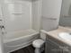 Bathroom with tub-shower, tile flooring, toilet, vanity, and a sink with brushed-metal faucet at 14208 Castle Abbey Ln, Charlotte, NC 28277