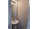 Small powder room with pedestal sink and a round mirror with an overhead light at 14208 Castle Abbey Ln, Charlotte, NC 28277