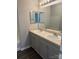 Bathroom with double sink vanity with grey cabinets, and large mirror with vanity lighting at 14208 Castle Abbey Ln, Charlotte, NC 28277