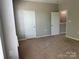 Spacious bedroom featuring neutral walls, carpeted flooring, and two bright white doors at 14208 Castle Abbey Ln, Charlotte, NC 28277