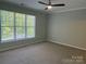 A bright, carpeted bedroom with large windows providing ample natural light at 14208 Castle Abbey Ln, Charlotte, NC 28277