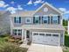 Charming two-story home with a gray exterior, black shutters, and attached two-car garage at 1717 Mill Creek Sw Ln, Concord, NC 28025