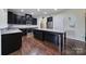 Spacious kitchen with dark cabinets, granite countertops, stainless appliances, and a large island at 1717 Mill Creek Sw Ln, Concord, NC 28025