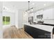 Bright kitchen with white cabinets, stainless steel appliances, and a black island with a quartz countertop at 2043 Greenoak Dr, Shelby, NC 28152