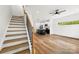 Open-concept living area with hardwood floors, stairs, and a modern kitchen in the background at 2043 Greenoak Dr, Shelby, NC 28152