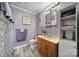 A purple bathroom featuring a single sink vanity, toilet, framed art, and white trimmed mirror at 216 W 16Th St, Kannapolis, NC 28081