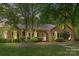 Charming brick home featuring a manicured front yard, a purple door, and mature trees for added privacy at 2234 Hamilton Mill Rd, Charlotte, NC 28270
