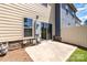 Back patio area featuring siding, stone accents, a concrete slab, and a mix of grass and mulch at 226 Scenic View Ln, Matthews, NC 28104