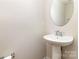Elegant powder room featuring a pedestal sink and a stylish round mirror at 226 Scenic View Ln, Matthews, NC 28104