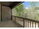 Covered outdoor deck with natural wood railing overlooking peaceful wooded backyard at 2596 Polo Ln, Maiden, NC 28650