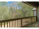 Outdoor deck with wood railing offering serene views of the lush, wooded backyard at 2596 Polo Ln, Maiden, NC 28650