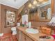Well-lit bathroom with a spacious vanity, decorative mirrors, and neutral tones at 2620 Park Rd, Charlotte, NC 28209