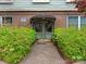 Charming front entrance with green door and brick facade surrounded by lush greenery and convenient walkway to the building at 2620 Park Rd, Charlotte, NC 28209