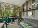 Enclosed porch featuring wicker furniture, decorative wall accents, and a view of the surrounding trees at 2620 Park Rd, Charlotte, NC 28209