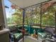 Cozy porch with wicker furniture, potted plants, and a view of the lush backyard and trees at 2620 Park Rd, Charlotte, NC 28209