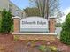 Entrance to Dilworth Edge Condominiums with a brick sign and pineapple accents at 2620 Park Rd, Charlotte, NC 28209