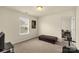 Small, carpeted bedroom with a brown leather ottoman, TV, and large window with natural light at 269 Keating Place Dr, Fort Mill, SC 29708