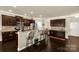 A kitchen with an island, breakfast bar, and dark cabinets overlooking an open living area at 269 Keating Place Dr, Fort Mill, SC 29708