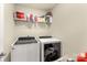 Practical laundry room with modern front-loading washer and dryer and shelf storage at 269 Keating Place Dr, Fort Mill, SC 29708
