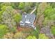 Aerial view of a lakeside home surrounded by lush greenery and manicured lawns at 272 Harbor Ridge Dr, Statesville, NC 28677