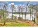 Backyard view of a lakefront property with a private dock, seating and fire pit area at 272 Harbor Ridge Dr, Statesville, NC 28677