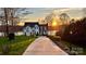 Inviting two-story home with a long driveway and manicured lawn at sunset at 272 Harbor Ridge Dr, Statesville, NC 28677
