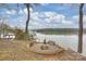Lakeside fire pit with a built in stone surround and beautiful views of the water at 272 Harbor Ridge Dr, Statesville, NC 28677