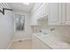 Well-lit laundry room with utility sink, ample cabinet space, and a drying rack at 272 Harbor Ridge Dr, Statesville, NC 28677