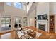 Bright living room featuring hardwood floors, fireplace, and doors to a balcony overlooking a lake at 272 Harbor Ridge Dr, Statesville, NC 28677