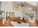Bright living room with high ceilings, hardwood floors, and a cozy seating area with a tan leather sectional at 272 Harbor Ridge Dr, Statesville, NC 28677