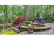 Beautiful backyard oasis featuring a tranquil pond, waterfall, and outdoor seating area at 305 Caledonia Way, Waxhaw, NC 28173