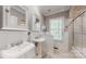 Well-lit bathroom with dual sinks, white cabinets, a shower, and classic fixtures at 305 Caledonia Way, Waxhaw, NC 28173