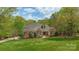 Traditional two-story brick home with a well-manicured lawn, mature trees, and tasteful landscaping at 305 Caledonia Way, Waxhaw, NC 28173