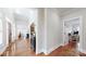Hallway featuring hardwood floors, an open doorway, and views into other rooms of the home at 305 Caledonia Way, Waxhaw, NC 28173