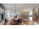 Kitchen and dining area with dark wood table, brick fireplace, and wooden floors at 305 Caledonia Way, Waxhaw, NC 28173