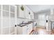 Charming laundry room with beadboard walls, a sink, washer, dryer, and checkered floors at 305 Caledonia Way, Waxhaw, NC 28173