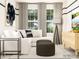 Comfortable living room showcasing a white sofa, stylish ottomans, a wooden cabinet, and large windows with natural light at 4136 Skyboat Cir, Fort Mill, SC 29715