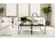 Modern living room with white sofa, black coffee table, neutral walls, and decorative plants at 4136 Skyboat Cir, Fort Mill, SC 29715