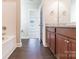 Bathroom with a tub, wooden vanity, granite countertops, and wood-look floors offering style and functionality at 4176 River Run Cir, Hickory, NC 28602