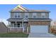 Charming two-story home featuring stone accents, a covered porch, and an attached two-car garage at 4176 River Run Cir, Hickory, NC 28602