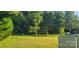 Lush backyard featuring green lawn space and lots of mature trees at 426 Summer Ridge Rd, Stanley, NC 28164
