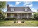 Charming brick home featuring a cozy front porch, dormer windows and well-maintained landscaping at 44392 Dennis Rd, Albemarle, NC 28001