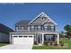 Charming two-story home featuring a white garage door and gray siding, complete with manicured front lawn at 517 Durango Way, Denver, NC 28037