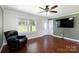 Cozy living room with hardwood floors, a large window, a ceiling fan, and tv at 5381 Mount Carmel Rd, Heath Springs, SC 29058