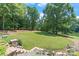 Beautifully landscaped backyard sloping down to a serene lake, with stone steps leading to the waterfront at 542 Lochaven Rd, Waxhaw, NC 28173
